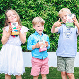 Children holding up packs of Small & Wild herbal and fruit teas for kids