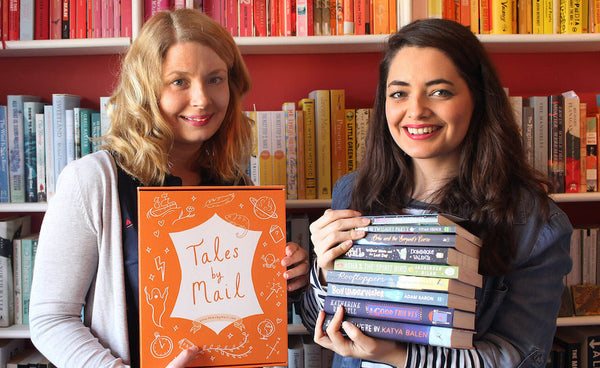 two women holding books and postal book subscription box