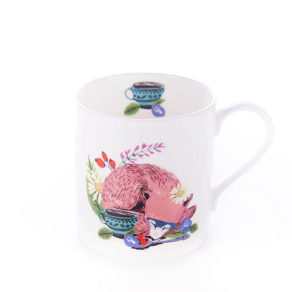 A child-sized mug with a colorful illustration of a fox, tea cups, and flowers on it.